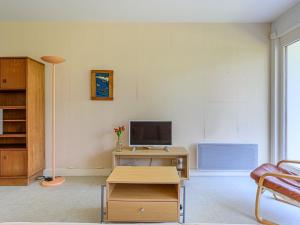 a living room with a desk with a television at Apartment Men Er Bellec-4 by Interhome in Saint-Philibert +17 photos