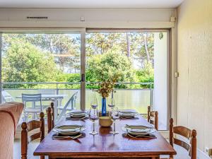 a table with glasses and plates on it with a balcony at Apartment Men Er Bellec-4 by Interhome in Saint-Philibert