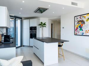 a kitchen with white walls and a black counter top at Apartment Entre Bateau et Mer by Interhome in Santo Stefano al Mare