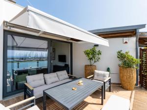 a patio with a couch and a table at Apartment Entre Bateau et Mer by Interhome in Santo Stefano al Mare