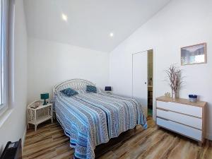 a bedroom with a bed and a dresser and a mirror at Holiday Home Maison du bois by Interhome in Les Mathes