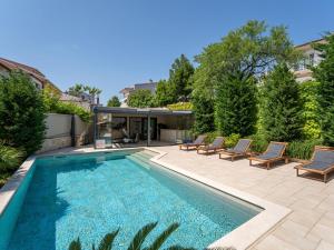 a swimming pool with chairs and a house at Apartment Dita-2 by Interhome in Crikvenica +31 photos