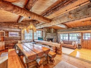 a living room with a large wooden table and a fireplace at Holiday Home Lumikenttien kutsu by Interhome in Kuusamo