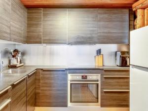 a kitchen with wooden cabinets and a stainless steel oven at Holiday Home Lumikenttien kutsu by Interhome in Kuusamo +22 photos