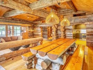 a dining room with a wooden table in a log cabin at Holiday Home Lumikenttien kutsu by Interhome in Kuusamo