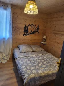 Chalet de montagne familial في Montferrier: غرفة نوم بها سرير في جدار خشبي
