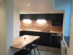a kitchen with a wooden table and a sink at Le duplex d'Abi in Saint-Étienne