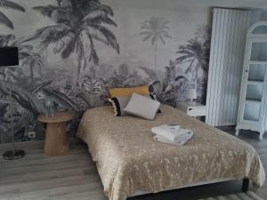 a bedroom with a bed with palm trees on the wall at Brive, La Villa Bellevue in Buissou