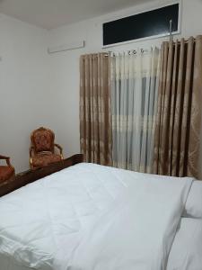 VenticanoCasa delle Foglie的一间卧室，里面有一张白色床和两把椅子。