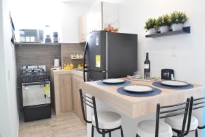 a kitchen with a table with chairs and a refrigerator at Apartamento nuevo a 7 min de la Escuela de Cadetes in Bogotá +20 photos