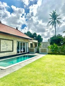 a house with a swimming pool and a palm tree at Aldi's House Villa in Mantaak