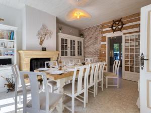 una sala da pranzo con tavolo, sedie e camino di Holiday Home Villa du Sourdonnet by Interhome a Les Mathes