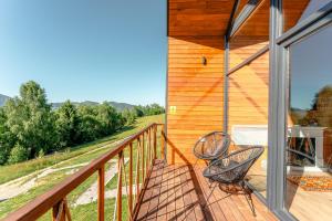 ein Balkon eines Hauses mit zwei Stühlen in der Unterkunft Suspended Tiny House in Drumu Carului