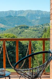 Ein Stuhl auf einer Veranda mit Blick auf die Berge in der Unterkunft Suspended Tiny House in Drumu Carului