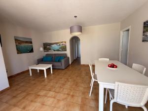 a living room with a table and a couch at Siestamar II in Cala'n Porter