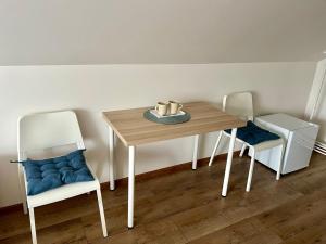 a dining room table with two chairs and a table with a candle at Kambarių nuoma Šventojoje in Palanga