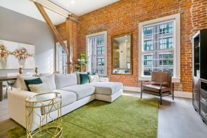 sala de estar con sofá blanco y pared de ladrillo en New Orleans Luxury Rentals - The Rex, en Nueva Orleans