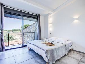 a bedroom with a bed and a large window at Holiday Home La Grange by Interhome in Torreilles