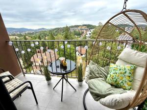 a balcony with a chair and a table with a view at Apartman Njegoš Lux Titova vila in Palisad