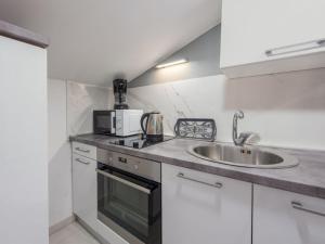 een keuken met een spoelbak en een magnetron bij Apartment Sofija-2 by Interhome in Karlobag
