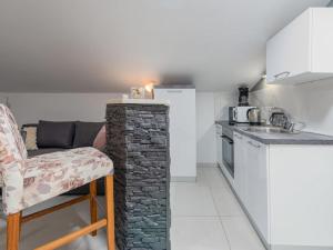 een keuken met een stenen pilaar en een tafel met een stoel bij Apartment Sofija-2 by Interhome in Karlobag