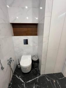 a bathroom with a toilet and a black marble floor at Arcadia Studio 238-1 in Odesa