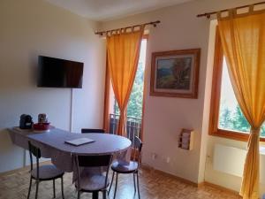 a dining room with a table and two windows at Casaclem in Menconico