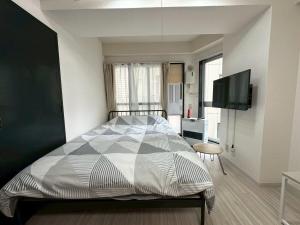a bedroom with a bed and a flat screen tv at Residence Hotel #3 窓エアコン 無料Wi-Fi in Kita-rokujō