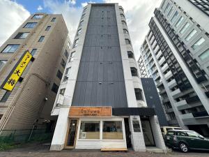 a tall building with a sign in front of it at Residence Hotel #3 窓エアコン 無料Wi-Fi in Kita-rokujō