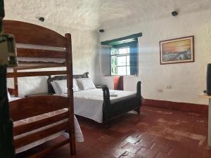 Un dormitorio con dos literas y una ventana. en El Refugio de la Villa, en Villa de Leyva