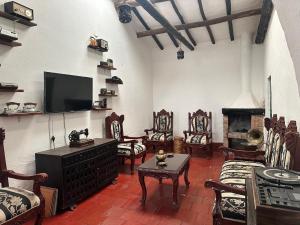 sala de estar con muebles y TV de pantalla plana. en El Refugio de la Villa, en Villa de Leyva