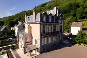 an aerial view of a house with a mountain in the background at La Demeure Du Tabellion in Mont-Dore