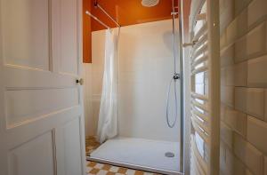 a shower with a glass door in a bathroom at La Demeure Du Tabellion in Mont-Dore