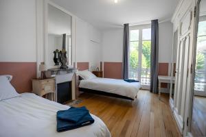 a hotel room with two beds and a mirror at La Demeure Du Tabellion in Mont-Dore