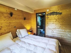 a bedroom with a bed in a wooden wall at Chalet Altavista by Interhome in Ziano di Fiemme