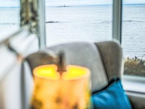 a seat with a view of the ocean from a window at Holiday Home Waters Edge by Interhome in Lossiemouth