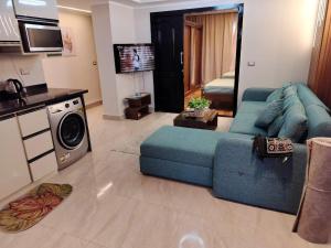 Una sala de estar con un sofá azul y una cocina. en Porto Marine Chalet - Sea View, en El Alamein 3 fotos más