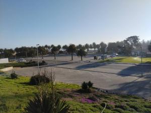 un aparcamiento vacío con palmeras y una calle en CBD Suite on Mole Beach self catering, en Swakopmund 1 foto más