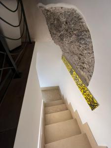 una scala con un muro di pietra e un righello giallo di La Casetta di Nonno Angelo - Amalfi Coast a Vietri 1 altra foto