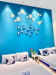 a bedroom with two beds and a blue wall with pictures at The Blue Memories Homestay with Mediterranean Style in Sungai Pelik