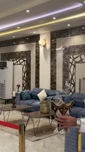 a living room with a blue couch and a table at المحرق للشقق المخدومة in Al Hofuf