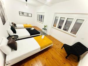 a bedroom with two beds and a chair in it at Luxury rooms, Lisbon city centre in Lisbon +63 photos
