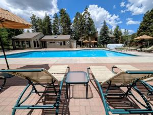 a swimming pool with two chairs and a table at Flying Dutchman 1155 by SummitCove Lodging in Keystone