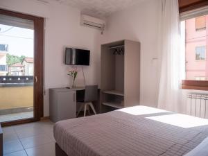 a bedroom with a bed and a desk and a window at Hotel RB Venice in Marghera