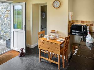 a kitchen with a wooden table and a microwave at River View Pateley - Uk47337 in Pateley Bridge