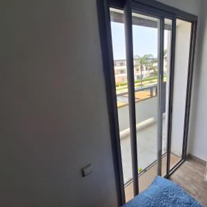 a bedroom with a door with a view of a balcony at Appartement marbella beach in Mansouria