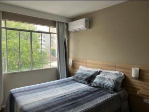 a bedroom with a bed with a window at Vicz Palace Hotel in Curitiba