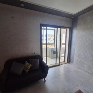 a living room with a couch and a sliding glass door at Appartement marbella beach in Mansouria +3 photos