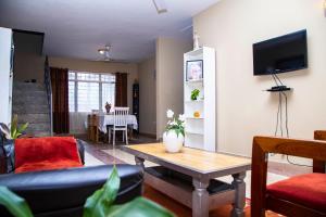 una sala de estar con un sofá y una mesa en Eliogemi Guest Room, en Gbawe