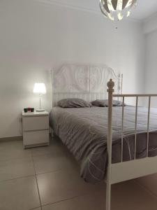 a bedroom with a bed and a lamp on a night stand at Casa Rainha Amélia in Monte Gordo